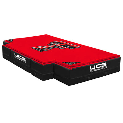 A red and black UCS high jump landing area with a large black and red Texas Tech logo on top, shown on a plain white background.