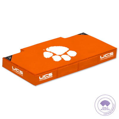 An orange high jump landing area with white printed logos and the Clemson white paw print graphic, shown on a plain white background. A circular 'World Athletics Certified Standard' badge appears in the bottom right corner.