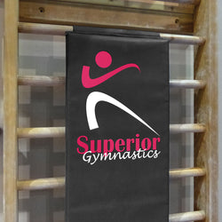 Stall bar pad with a black background featuring a white and pink logo of a gymnastics training facility.